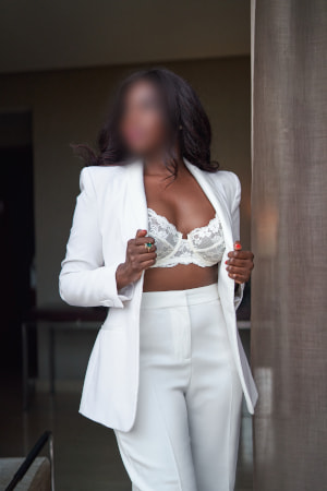Elite ebony woman in a white suit with the jacket undone