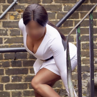 Busty ebony girl in a white dress with her face blurred
